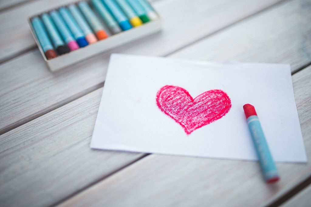 heart drawing in red with pack of crayons