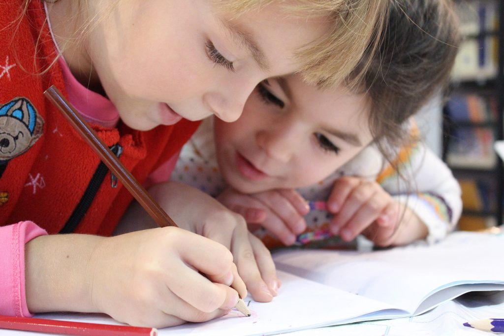 two children writing on a page