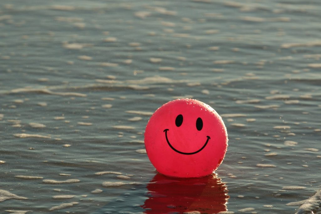 ball with smiley face sitting on water